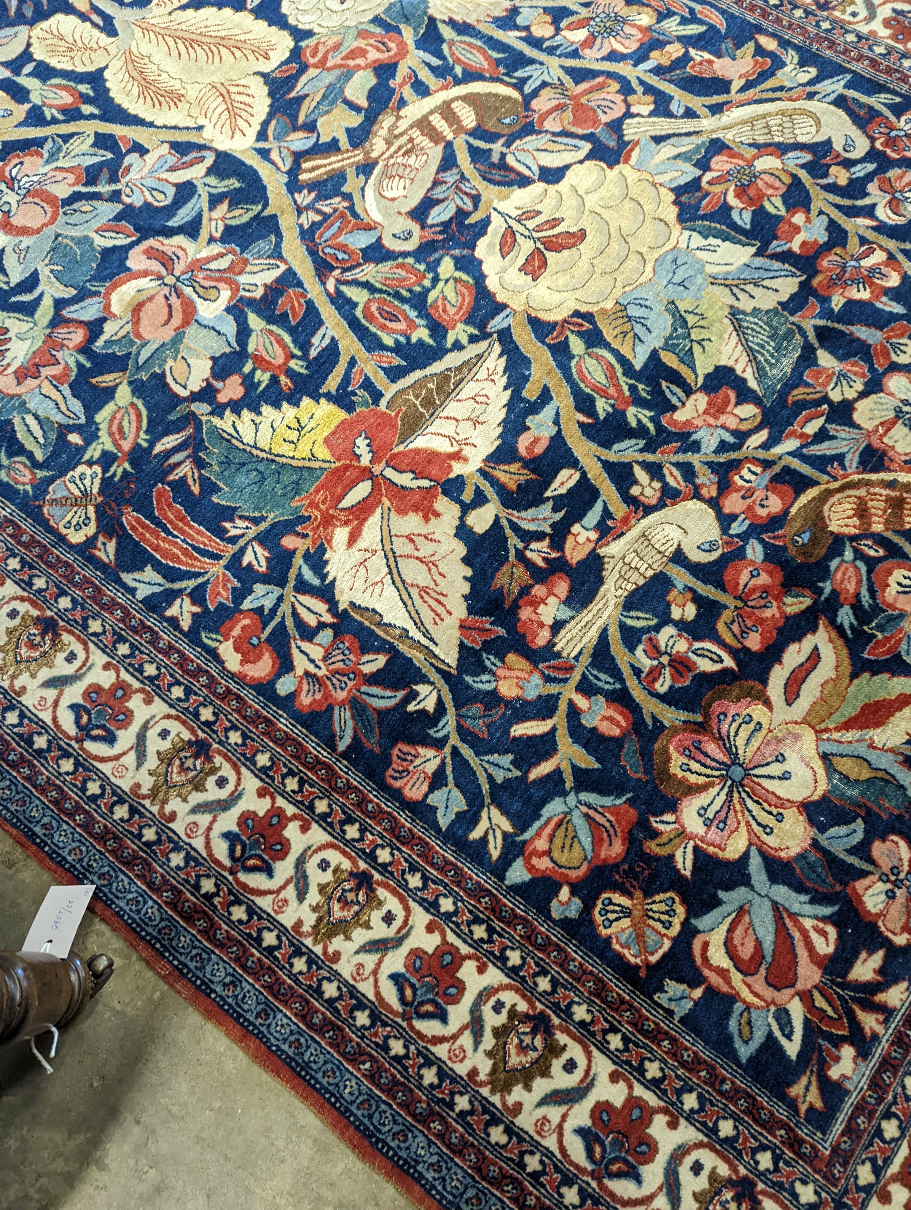 A Kirman blue ground rug woven with birds amongst flowering branches, 205 x 136cm